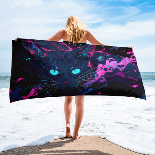 Person holding a colorful towel with a cat design on a beach
